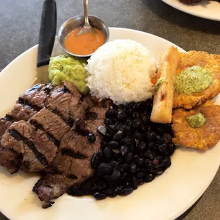 Parilla Mojito; citrus-marinated steak served with rice, black beans, fried yuca, tostones, guasacaca.