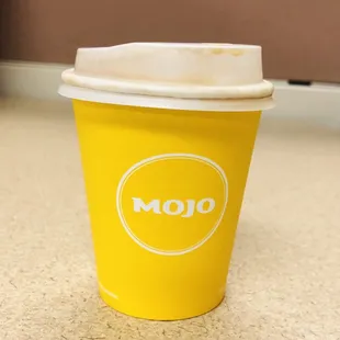 a yellow cup with a white lid