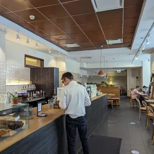 a man standing at a counter in a coffee shop