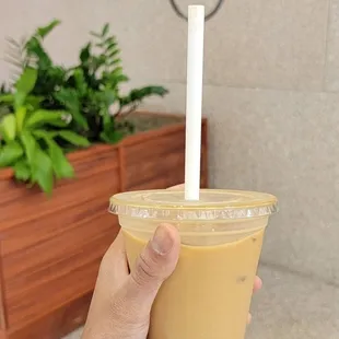 a hand holding a cup of iced coffee