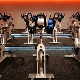 The cycling room that is dimly lit during a class.  The best equipment and weights to work the entire body.
