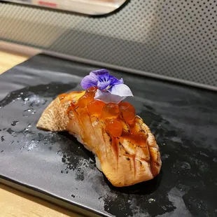 a piece of salmon on a black plate