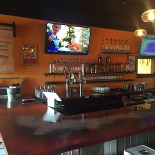 a bar area with a television and bar stools