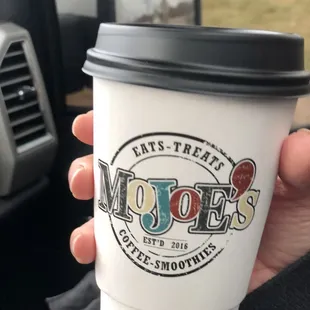 a hand holding a coffee cup