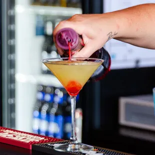 a person pouring a cocktail
