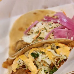 two tacos with cheese and onions