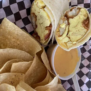Bacon egg cheese and potato breakfast burrito with chips and queso. Nom!