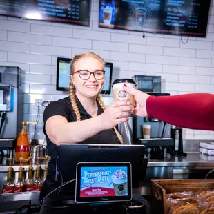 a woman serving a cup of coffee