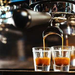 a shot of coffee being poured into shot glasses