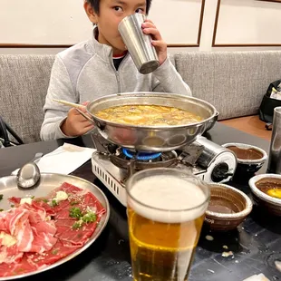a young boy drinking a glass of beer