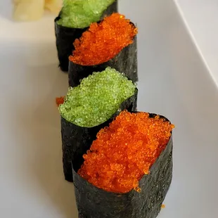 three sushi rolls on a white plate