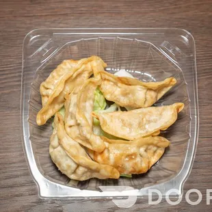 a close up of a fried dumpling in a plastic container