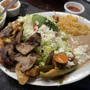 Cheese enchiladas with grilled steak and chicken on top