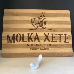 a wooden cutting board with the name molka xete on it