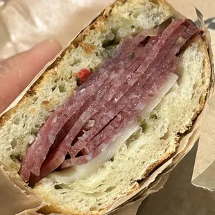 a hand holding a sandwich