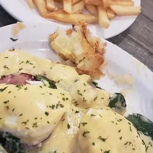 Egg Benedict with spinach and side of fries.