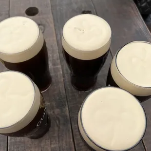 four glasses of beer on a wooden table