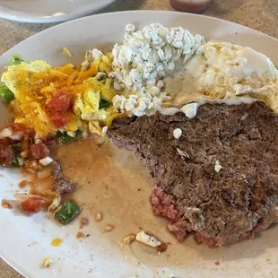 Half eaten hamburger steak and eggs.  I like my meat rare and they cook it perfectly over a flame broiler.  Yum
