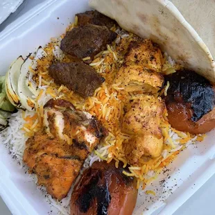 Salmon, beef shish, and boneless chicken plate on bed of rice with fire-roasted peppers, onion, and tomatoes.