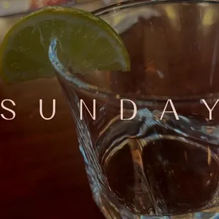 a glass of water with a lime wedge