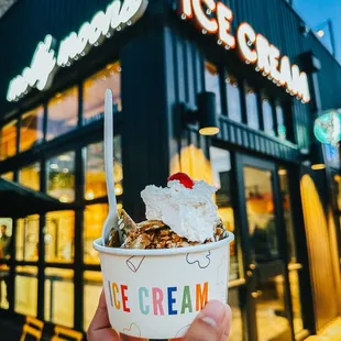 a hand holding a cup of ice cream