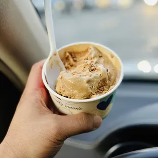 a hand holding a cup of ice cream