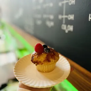 a hand holding a cupcake