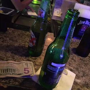 two beer bottles on a bar counter