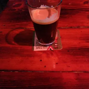 a glass of beer on a wooden table