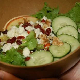 a person holding a bowl of salad