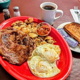 Morning ribeye steak eggs over easy home fried potatoes salsa on the side sourdough toast and coffee
