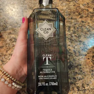 a hand holding a clean bottle of alcohol