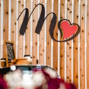 a wooden wall with a sign and flowers