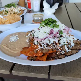 I still drive 35 minutes for these -  half red half green chilaquiles topped with carne asada.