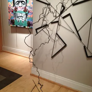 An amazing steel piece resembling an electric current, titled Epiphany, by Leslie Martin with a fun Acrylic by Eliseo Casiano!