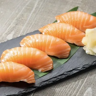 three pieces of salmon on a slate platter