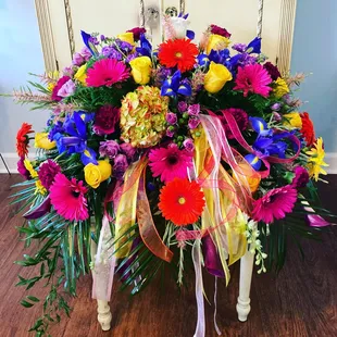 A kaleidoscope of colors casket spray.