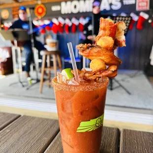 Momma&apos;s Mary: Tito&apos;s Handmade Vodka, signature Bloody Mary mix, dry rub-seasoned rim, Memphis Mojo wing, cheese curd, bacon, garnishes