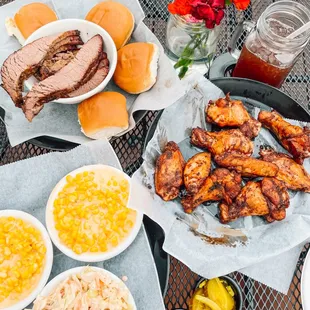 Chicken wings, brisket, cheesy corn, cole slaw, mustard, and pickles.