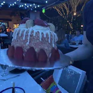 a woman serving a large cake