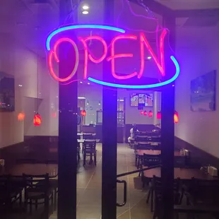 a neon sign in the window of a restaurant