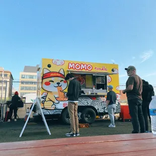two men standing in front of a food truck