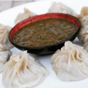 a plate of dumplings with dipping sauce