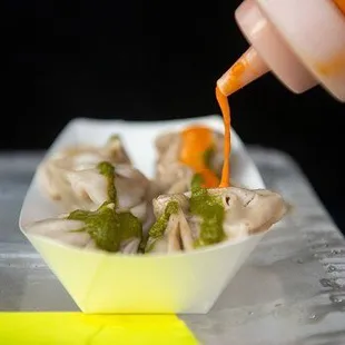 sauce being poured over the dumplings
