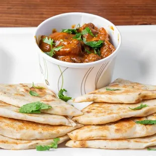 a plate of flatbreads and a bowl of sauce