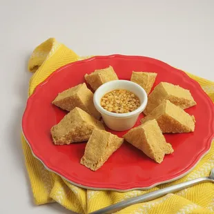a red plate with a bowl of food