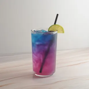 a blue and purple drink with a slice of lime