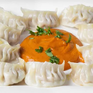 a plate of dumplings with sauce