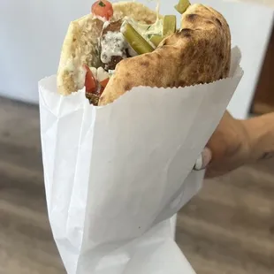 a hand holding a sandwich