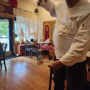 a man pouring kebab into a glass
